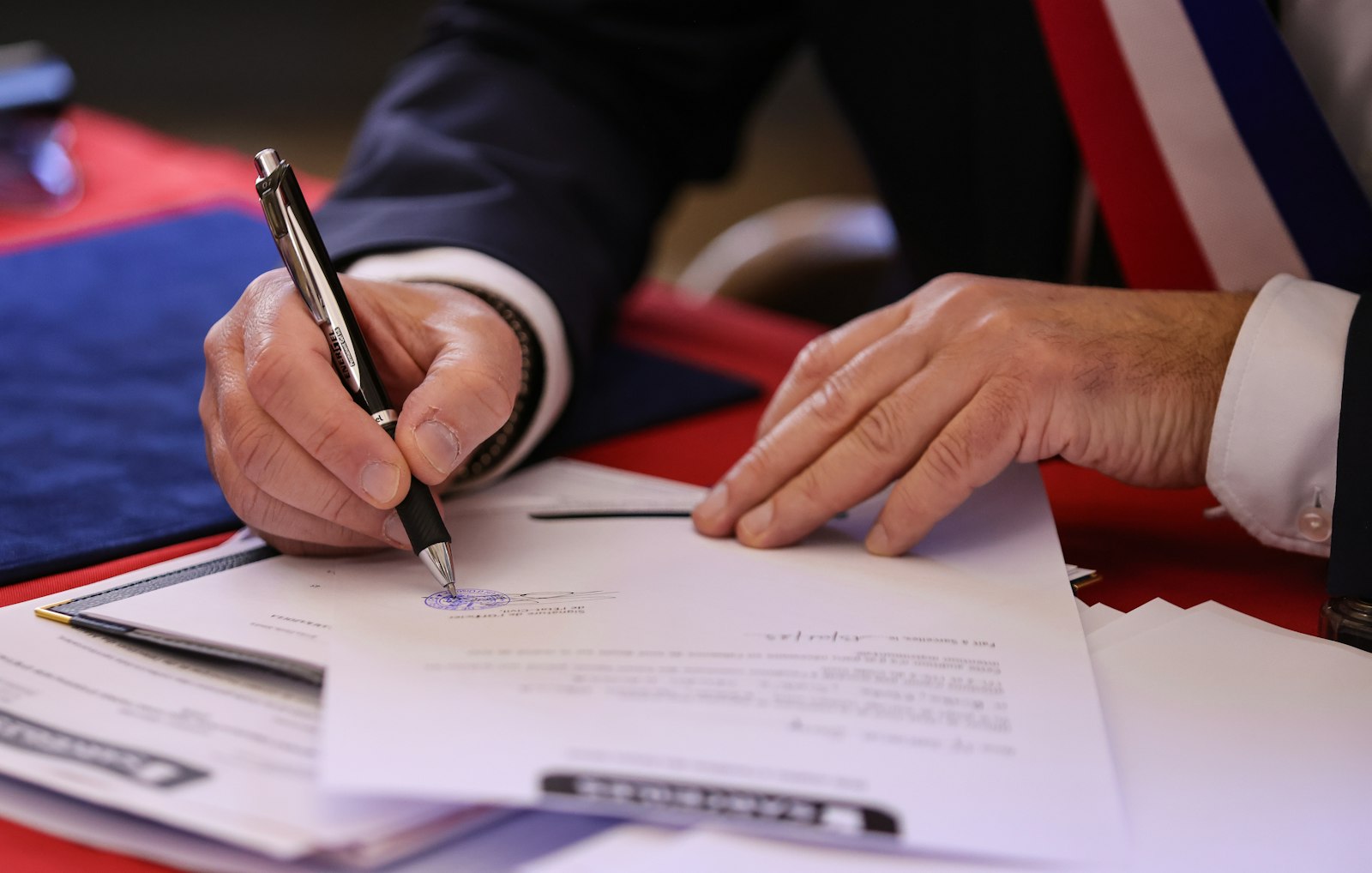 Persona firmando un documento con un bolígrafo
